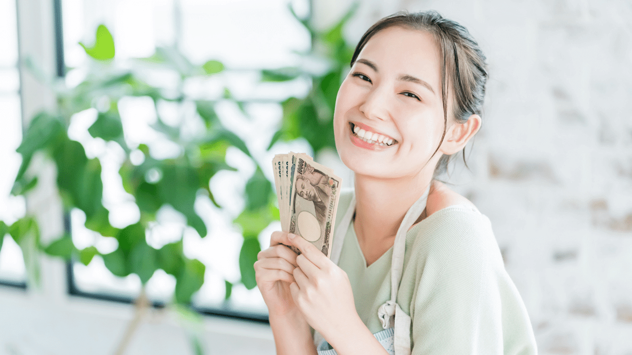 笑顔でお金を持つ女性